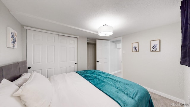 carpeted bedroom with a closet, baseboards, and a textured ceiling