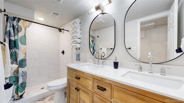 full bathroom with a sink, visible vents, tiled shower, and toilet