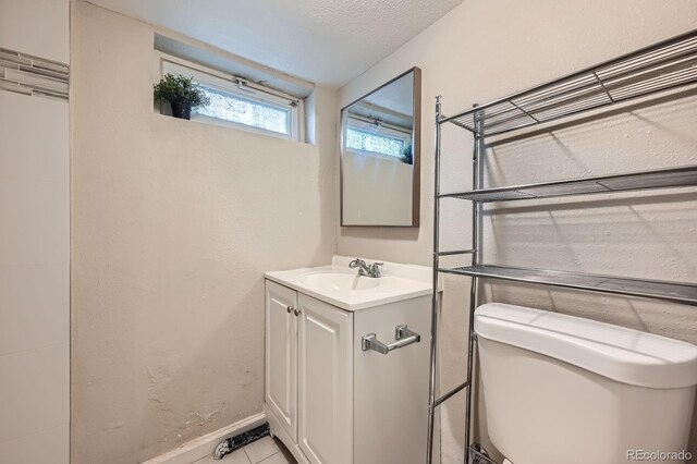 1746 Galena St, Aurora, CO 80010 - bathroom featuring vanity, tile patterned flooring, baseboards, and toilet