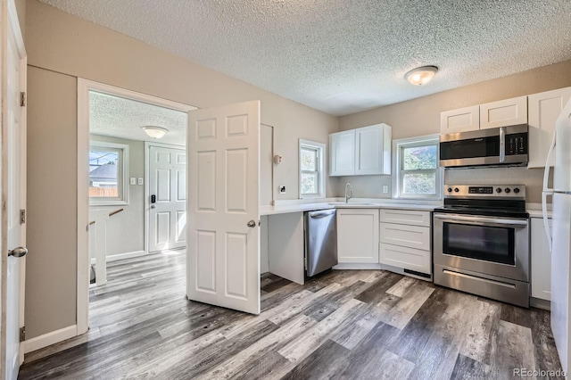 1746 Galena St, Aurora, CO 80010 - kitchen with stainless steel appliances, a textured ceiling, a sink, light countertops, and dark wood-style floors