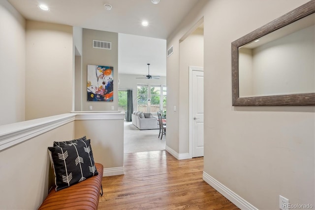 hall featuring wood finished floors, recessed lighting, and baseboards