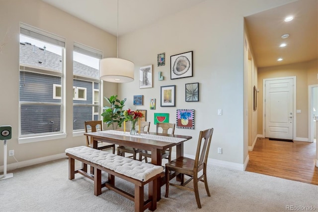 dining room featuring light colored carpet, baseboards, and recessed lighting