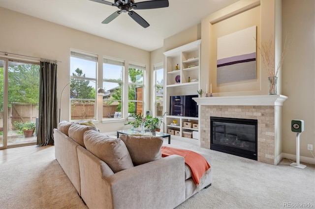 living area with carpet, ceiling fan, and a fireplace