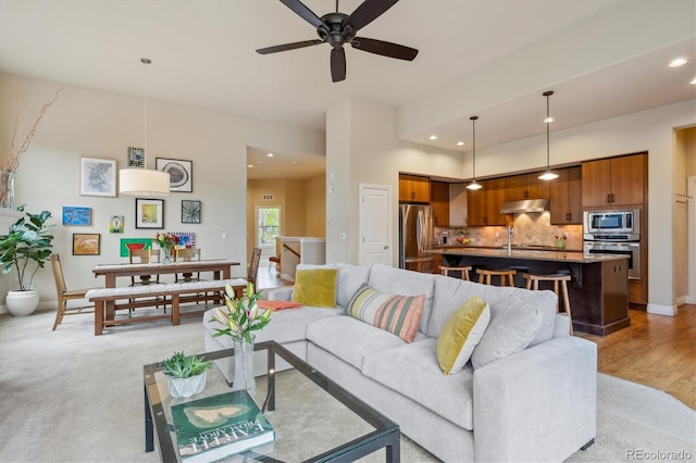 living room with recessed lighting, ceiling fan, light colored carpet, and baseboards