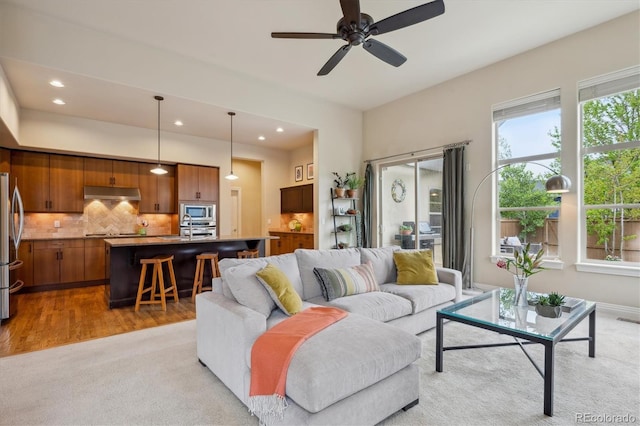 living area featuring recessed lighting, a ceiling fan, and light wood-type flooring