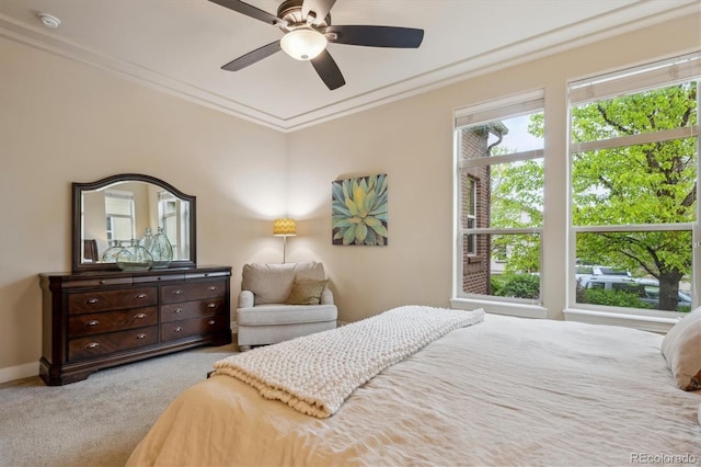 carpeted bedroom with ornamental molding, a ceiling fan, and baseboards