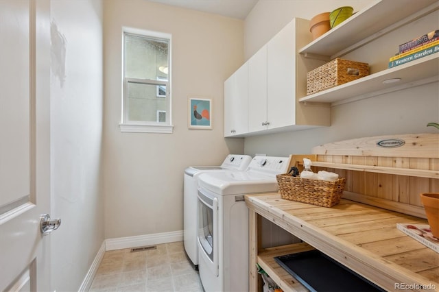 laundry room with baseboards, separate washer and dryer, and cabinet space