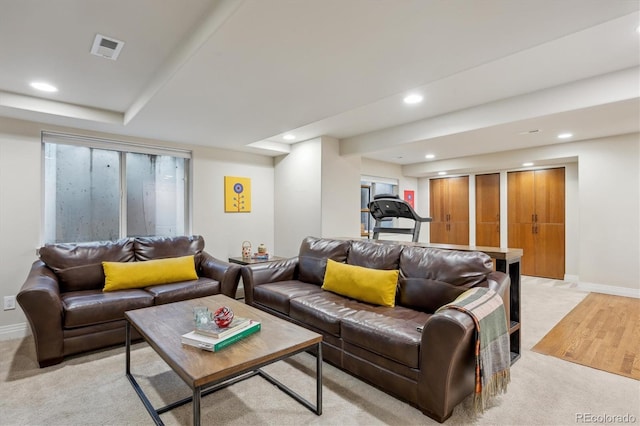 living room with recessed lighting, light colored carpet, and baseboards