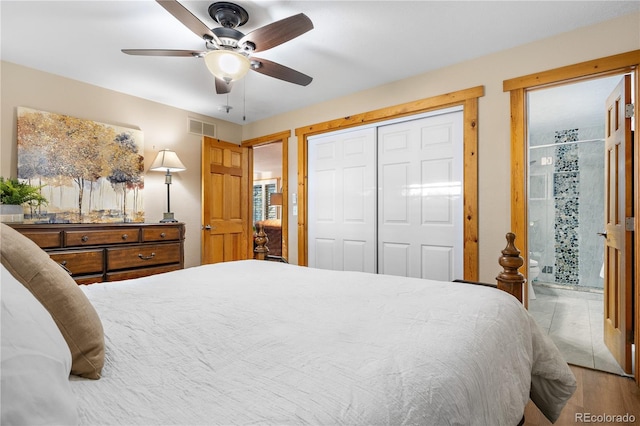 bedroom featuring ceiling fan, wood-type flooring, a closet, and ensuite bath