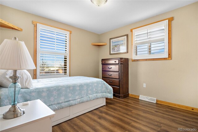 bedroom with dark hardwood / wood-style floors