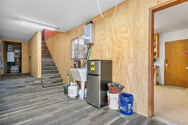 basement featuring dark hardwood / wood-style flooring and stainless steel refrigerator