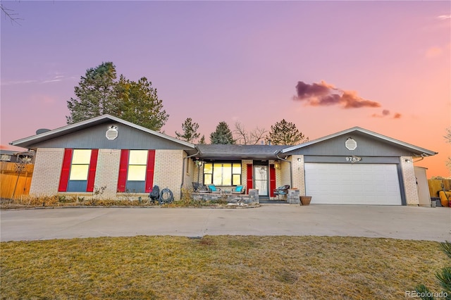 ranch-style home with a garage, a porch, and a yard