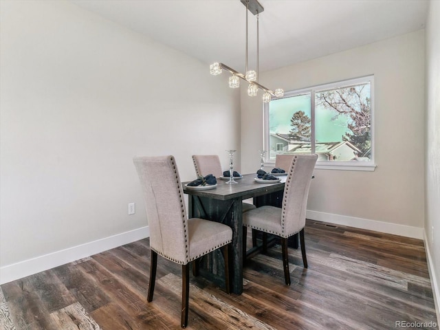 dining space featuring dark hardwood / wood-style floors and a notable chandelier