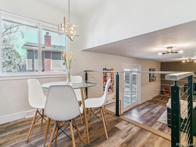 dining room with an inviting chandelier and dark wood-type flooring