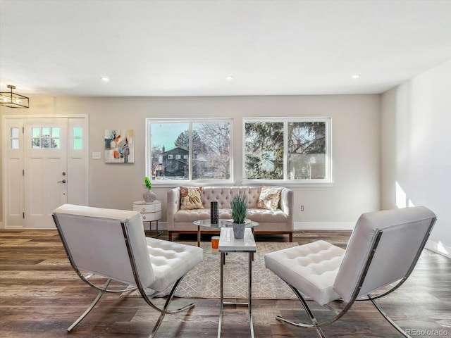 living room with plenty of natural light, dark wood-type flooring, and an inviting chandelier