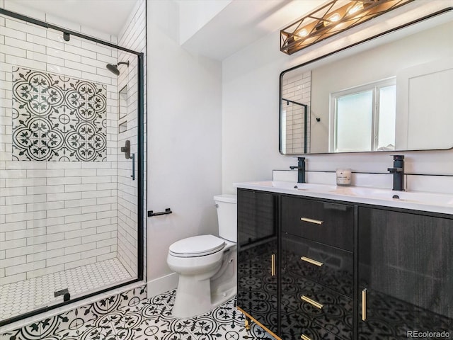 bathroom featuring tile patterned flooring, vanity, toilet, and walk in shower