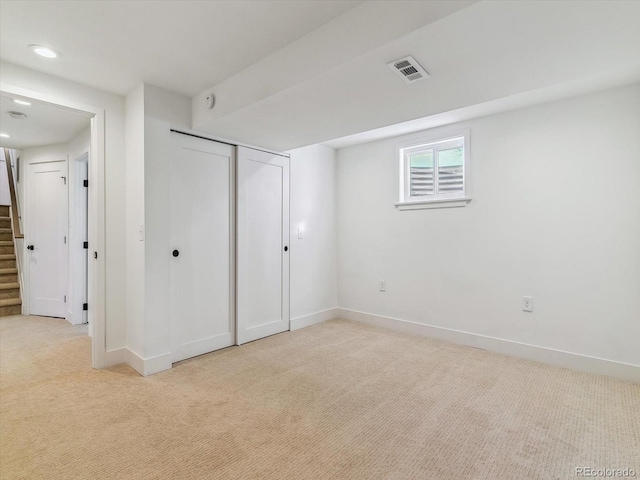 unfurnished bedroom featuring light carpet and a closet