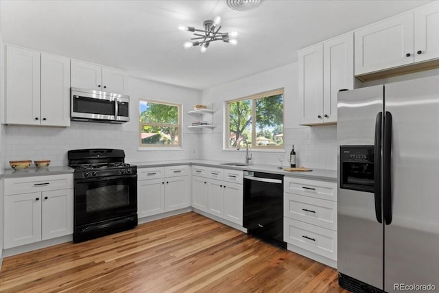 4125 Pierce St, Wheat Ridge, CO 80033 - kitchen featuring black appliances, backsplash, white cabinets, and a chandelier