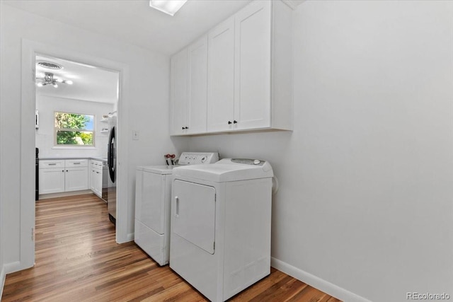 4125 Pierce St, Wheat Ridge, CO 80033 - laundry area with separate washer and dryer, cabinet space, and light wood-style floors