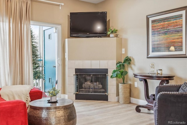 3847 Mossy Rock Dr Unit 104, Highlands Ranch, CO 80126 - sitting room featuring wood finished floors, baseboards, and a tile fireplace