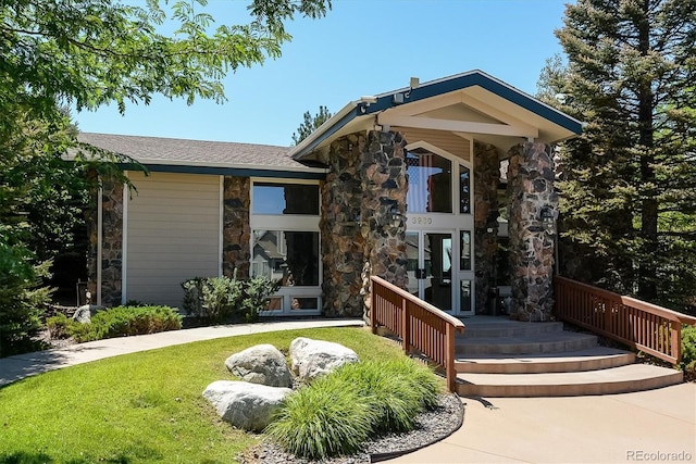 3847 Mossy Rock Dr Unit 104, Highlands Ranch, CO 80126 - back of house with stone siding and a yard