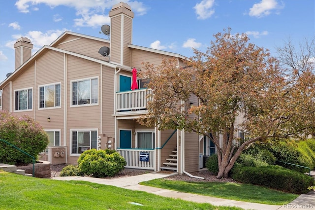 3847 Mossy Rock Dr Unit 104, Highlands Ranch, CO 80126 - back of house with a chimney, a balcony, and a yard