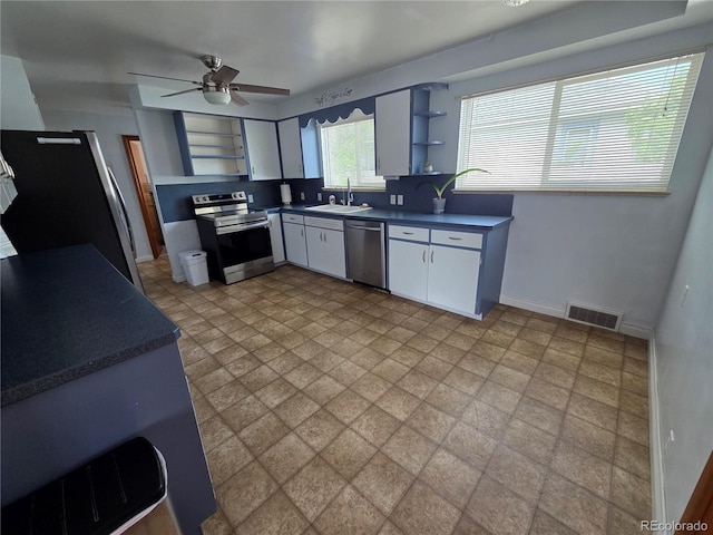 820 Walnut St, Julesburg, CO 80737 - kitchen with stainless steel appliances, open shelves, dark countertops, a sink, and a ceiling fan