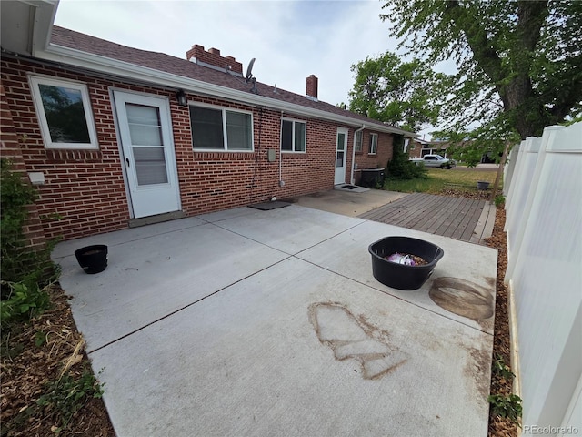 820 Walnut St, Julesburg, CO 80737 - rear view of property featuring brick siding, a patio area, and a chimney