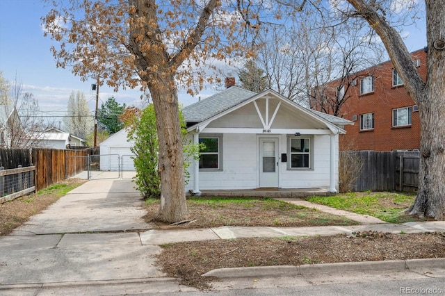 4046 S Bannock St, Englewood, CO 80110 - bungalow-style house featuring a gate, a garage, fence, a shingled roof, and covered porch