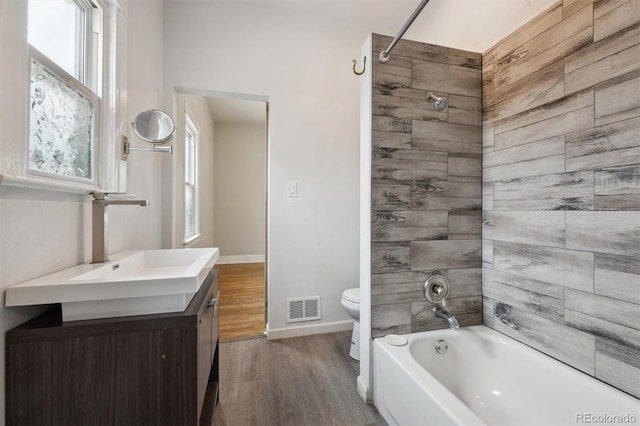 4046 S Bannock St, Englewood, CO 80110 - bathroom with visible vents, toilet, vanity, wood finished floors, and shower / bath combination