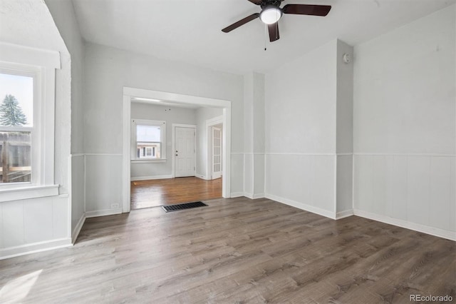 4046 S Bannock St, Englewood, CO 80110 - unfurnished room featuring wood finished floors, ceiling fan, visible vents, and a wainscoted wall