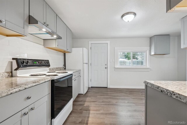 4046 S Bannock St, Englewood, CO 80110 - kitchen featuring light wood-style floors, under cabinet range hood, gray cabinets, backsplash, and electric range