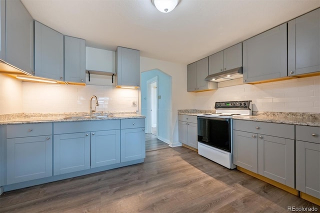 4046 S Bannock St, Englewood, CO 80110 - kitchen featuring white electric range, under cabinet range hood, dark wood-style flooring, a sink, and backsplash