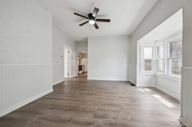 4046 S Bannock St, Englewood, CO 80110 - empty room with arched walkways, wainscoting, ceiling fan, and wood finished floors