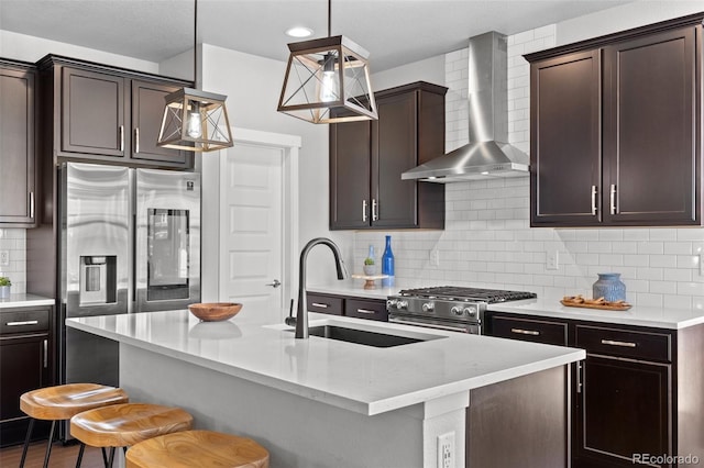 6700 Clay St, Denver, CO 80221 - kitchen featuring wall chimney range hood, high end stainless steel range, a breakfast bar area, dark brown cabinetry, and recessed lighting