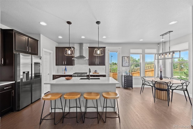 6700 Clay St, Denver, CO 80221 - kitchen with stainless steel refrigerator with ice dispenser, wall chimney range hood, light countertops, tasteful backsplash, and recessed lighting