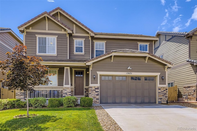 12631 Glencoe St, Thornton, CO 80241 - craftsman inspired home with a porch, driveway, a front yard, a tiled roof, and stone siding