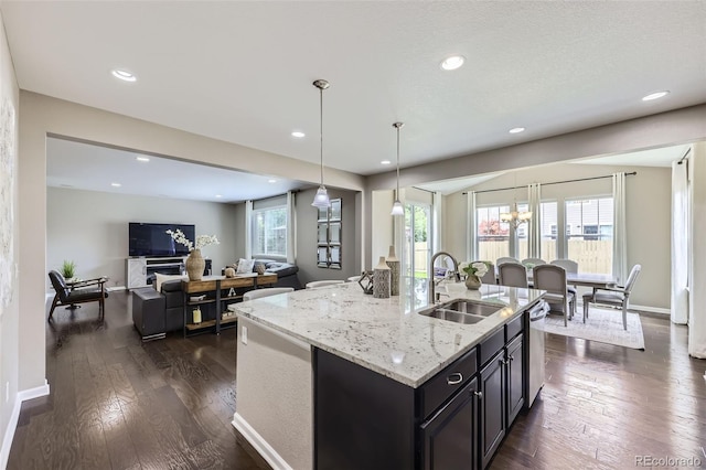 12631 Glencoe St, Thornton, CO 80241 - kitchen featuring open floor plan, light stone counters, hanging light fixtures, recessed lighting, and a center island with sink