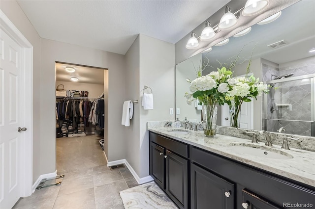 12631 Glencoe St, Thornton, CO 80241 - full bath featuring double vanity, a stall shower, a walk in closet, and tile patterned floors