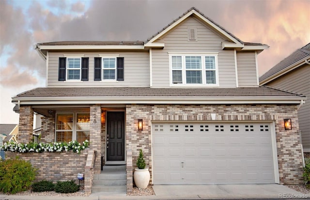 view of front of property featuring a garage, driveway, and brick siding