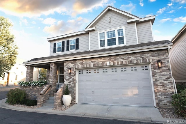 view of front of house featuring concrete driveway, brick siding, and an attached garage