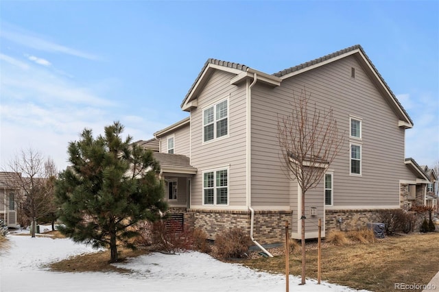 view of snow covered exterior featuring brick siding