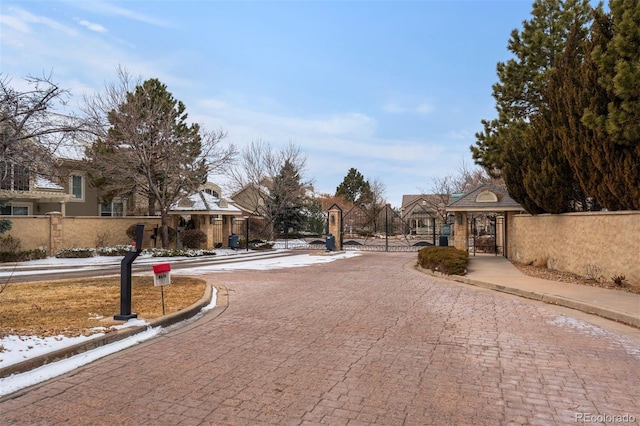 view of street featuring sidewalks, a gate, a residential view, and curbs