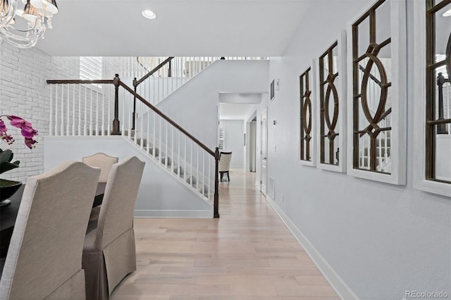 foyer entrance featuring recessed lighting, baseboards, stairway, light wood-type flooring, and an inviting chandelier