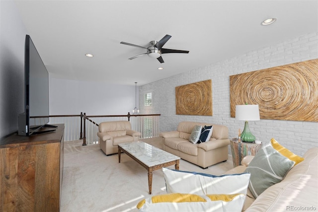 living room with light colored carpet, ceiling fan, and brick wall