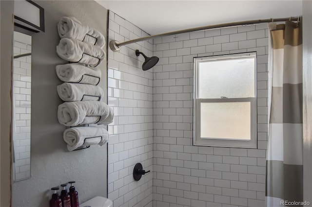 bathroom with toilet, walk in shower, and a healthy amount of sunlight