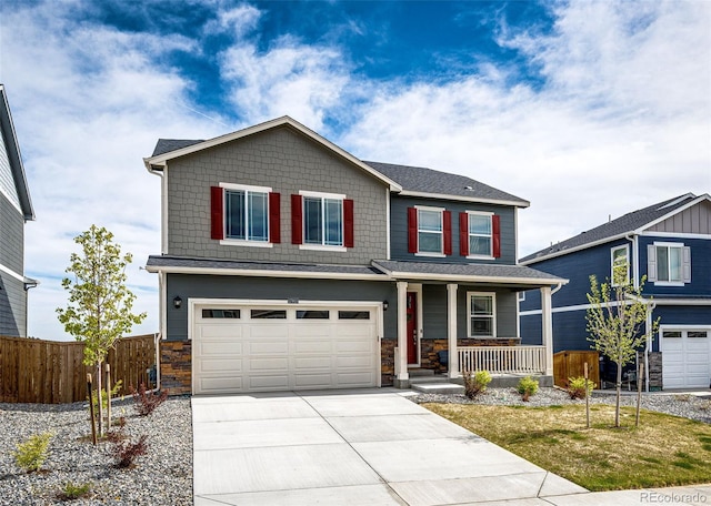 craftsman-style home with covered porch, fence, a garage, driveway, and stone siding