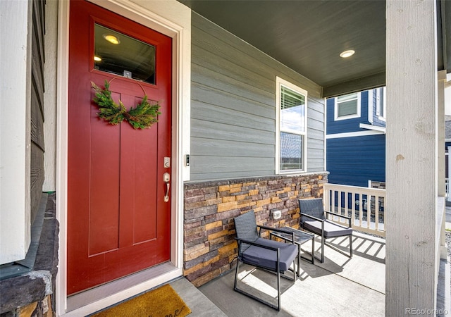 entrance to property with covered porch and stone siding
