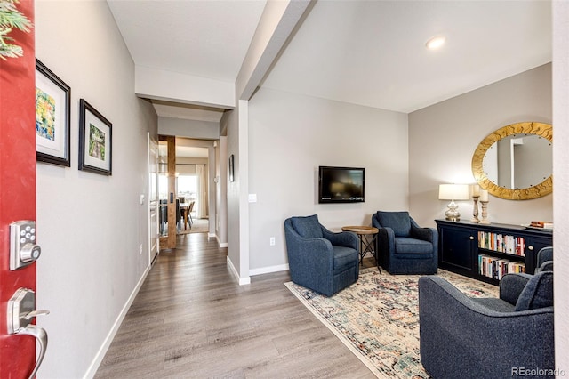 living area featuring wood finished floors, baseboards, and recessed lighting