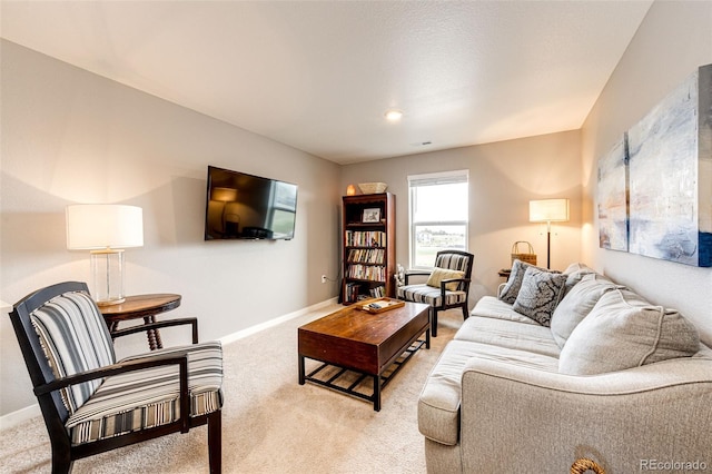 living area featuring light colored carpet and baseboards